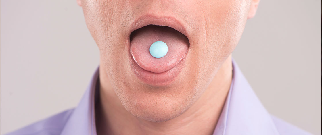 man swallowing a pill