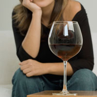 woman looking at glass of wine