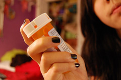 woman holding a bottle of pills