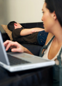 wife on computer while man is sleeping