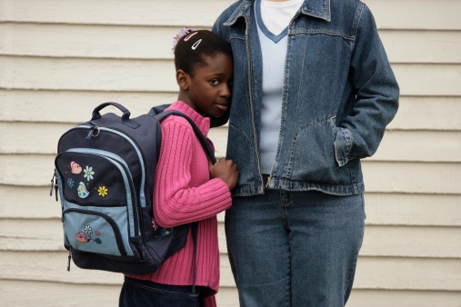 African American teenage girl takes refuge by her mom's side