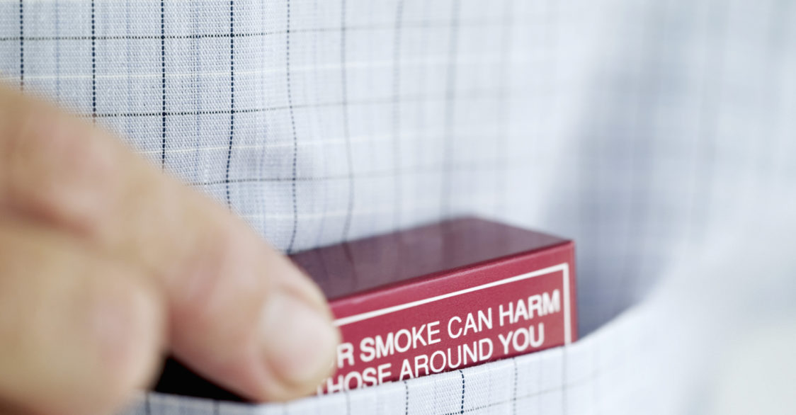 man putting pack of cigarettes in pocket