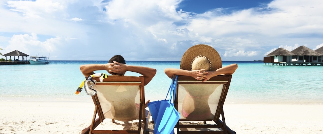 Couple relaxing on long chairs on a beach