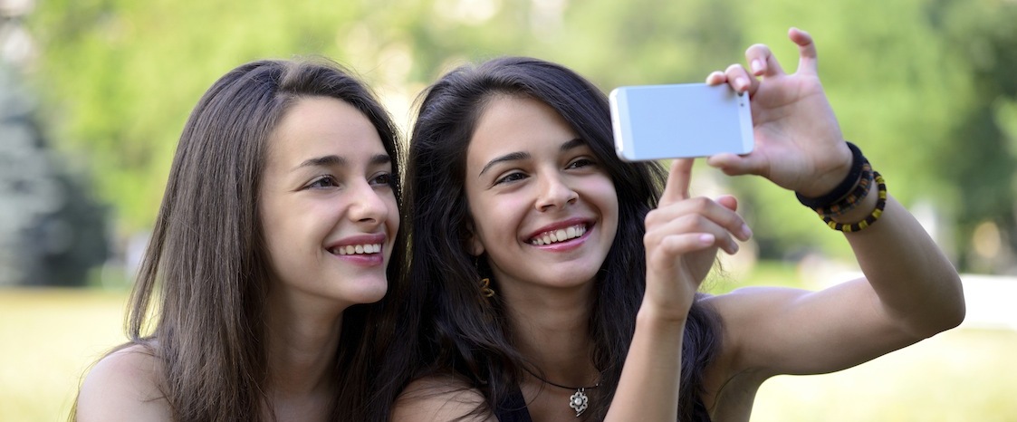 Two girls pointing on smartphone