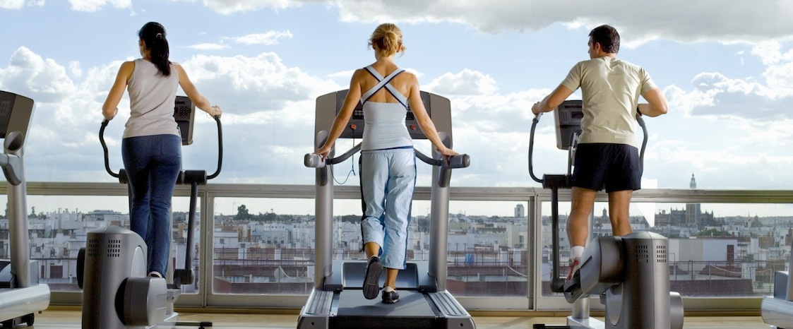 People using exercise equipment in front of a window