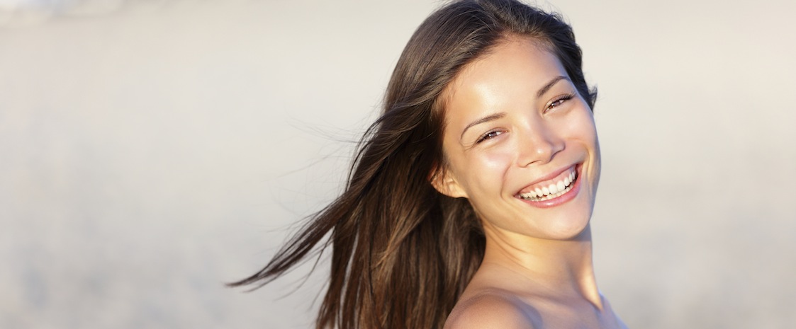 Asian woman on beach smiling happy. Beautiful young mixed race Asian Chinese / white Caucasian girl outdoors on summer beach.