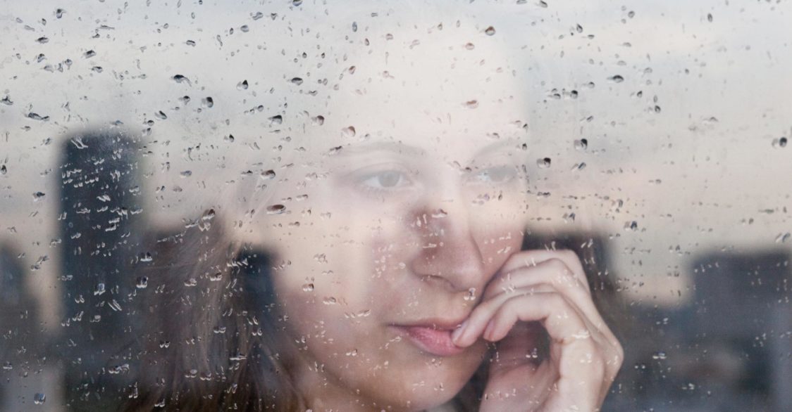 woman looking worried through window