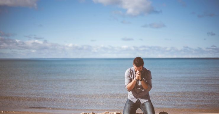 Man praying on the beach