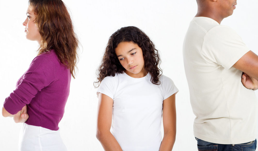teenage girl depressed standing in between parents turned away